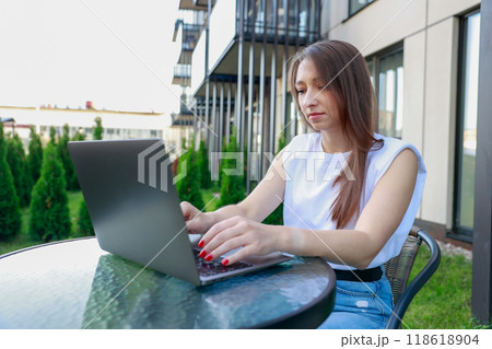 young woman lounges outdoors working laptop relaxed casual vibe captures essence remote work balance young woman lounges outdoors working laptop relaxed casual vibe captures essence remote work balance 118618904