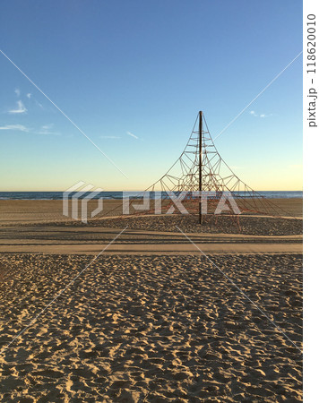 A tranquil beach landscape showcasing an intricate artistic sculpture with ropes set against a beautiful sunset backdrop A tranquil beach landscape showcasing an intricate artistic sculpture with ropes set against a beautiful sunset backdrop 118620010