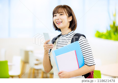 大学の教室で笑顔でスマホを操作する大学生　撮影協力：学校法人電波学園　東京電子専門学校 118621478