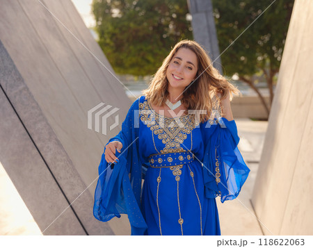 Travel to the United Arab Emirates, Abu Dhabi. Woman in blue Arabic dress near Sheikh Zayed Great white mosque. famous Abu Dhabi sightseeing. Travel to the United Arab Emirates, Abu Dhabi. Woman in blue Arabic dress near Sheikh Zayed Great white mosque. famous Abu Dhabi sightseeing. 118622063