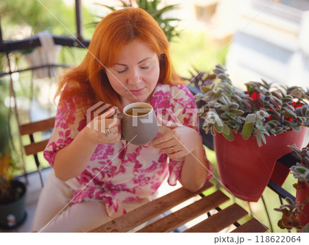 Woman drinking tea and relaxing at the balcony. Have rest after work Woman drinking tea and relaxing at the balcony. Have rest after work 118622064