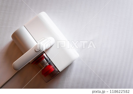 Vacuum cleaner for cleaning mattresses from mites with UV lamp and knocking out dust. Cleaning and disinfection of the mattress in the bedroom 118622582