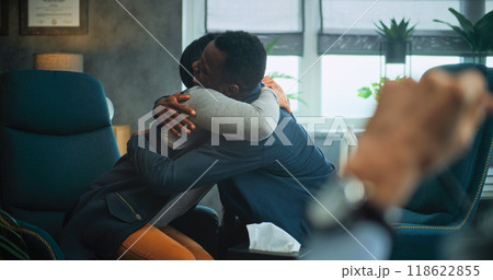 Happy multiethnic couple sit on chairs holding hands and hugging during couples therapy Happy multiethnic couple sit on chairs holding hands and hugging during couples therapy 118622855