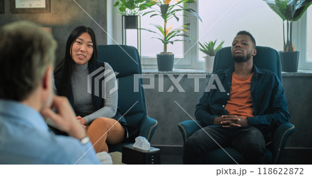 Multiethnic couple sit on chairs, discuss relationship problems with psychologist Multiethnic couple sit on chairs, discuss relationship problems with psychologist 118622872