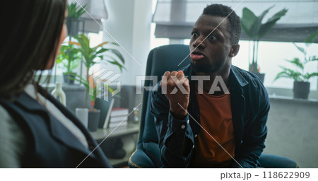 Aggressive man shouts at his girlfriend on counseling session with family psychotherapist 118622909