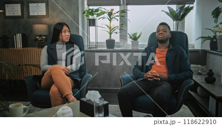 Back view of therapist listening to young family on counseling session 118622910