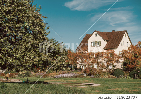 House with nice garden in fall. Flowers in the City Park of Bietigheim-Bissingen, Baden-Wuerttemberg, Germany, Europe. Autumn Park and house, nobody, bush and grenery 118623707