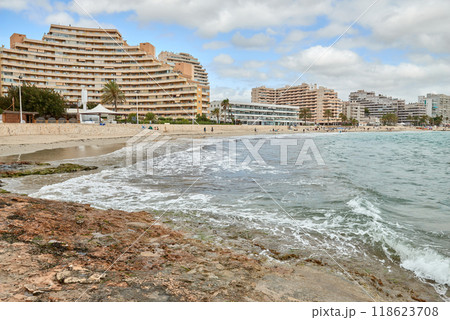 Breathtaking Aerial View of Calpe Spain Sandy Beach Azure Sea Dramatic Sky Summer Vacation European Coastal Paradise. Idyllic Mediterranean Seaside Town Calpe Turquoise Waters Rocky Shore Dramatic 118623708
