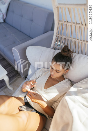 A Relaxing Afternoon A Woman Indulging in Leisure Time in the Comfort of Her Home 118625486