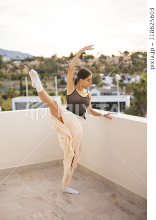 A graceful ballet dance outdoor performance takes place beautifully against the sunset sky A graceful ballet dance outdoor performance takes place beautifully against the sunset sky 118625603