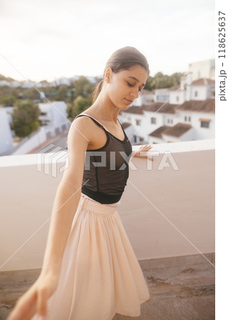 A Graceful Young Dancer Posing Elegantly on a Beautiful Balcony at Glorious Sunset Time A Graceful Young Dancer Posing Elegantly on a Beautiful Balcony at Glorious Sunset Time 118625637