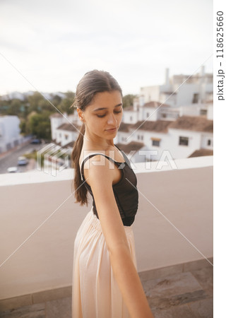 A Graceful Young Dancer is Posing Elegantly on a Beautifully Sunlit Balcony Space A Graceful Young Dancer is Posing Elegantly on a Beautifully Sunlit Balcony Space 118625660