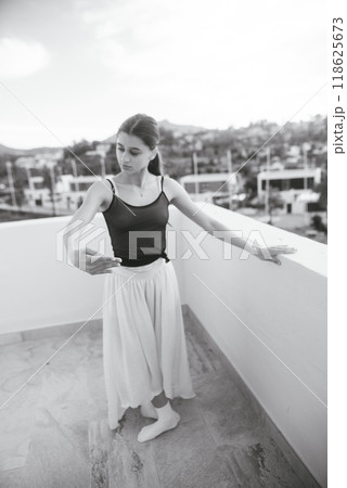An Elegant Ballet Dancer Gracefully Posing Outdoors in a Beautiful Monochrome Setting An Elegant Ballet Dancer Gracefully Posing Outdoors in a Beautiful Monochrome Setting 118625673