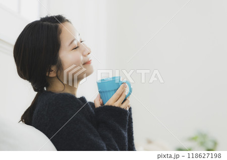 温かい飲み物を飲む女性 118627198