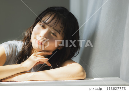 西陽の窓辺の女性 118627778