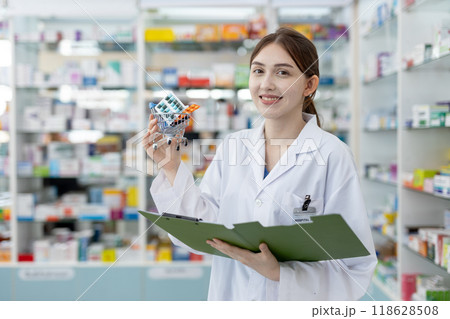 woman pharmacists holding shopping trolley with set medicine and record paper in drug store. woman pharmacists holding shopping trolley with set medicine and record paper in drug store. 118628508