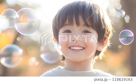 シャボン玉に囲まれて微笑む男の子の顔のクローズアップ 118629163