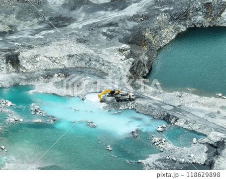 Open pit mine industry. Limestone quarry with backhoe and truck in operation. Heavy machinery in mining industry and construction material supply. Landscape of resource extraction in a industrial site 118629898