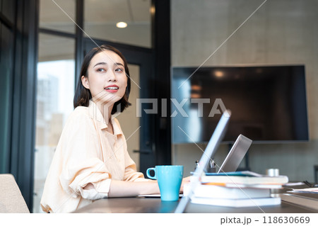 パソコン作業の合間に窓からの景色を見る女性 118630669