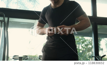 Young caucasian man bodybuilding with workout while wearing belt for safety while exercise. 118630832