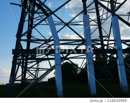 Electric tower and wires silhouetted against stunning sunset, symbolizing modern energy technology. Electric tower stands tall as a testament to innovative electricity solutions and infrastructure. 118630989