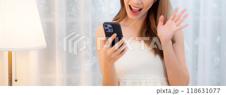 Young asian woman walking using smart phone for video call in living room at home. 118631077