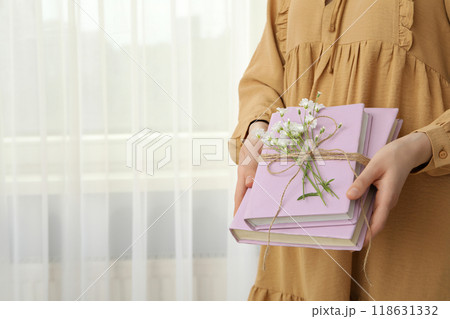 Aesthetics of books with flowers on a light background. 118631332