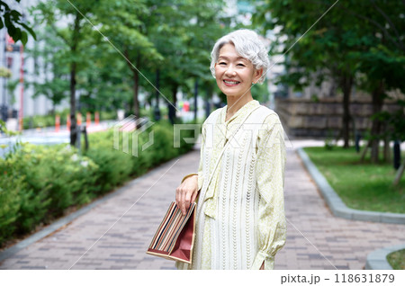 お出かけするショッピングバックを持ったかわいいシニア女性 お出かけするショッピングバックを持ったかわいいシニア女性 118631879