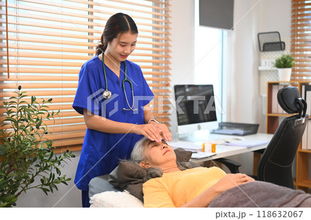 Physiotherapist doing Reiki treatment session to mature woman at clinic. Alternative medicine concept 118632067