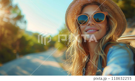 Pretty woman capturing memories, upper body out of car window, summer travel, high resolution image 118632255