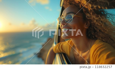 Woman on road trip, upper body out of car window, capturing moment, high resolution image 118632257