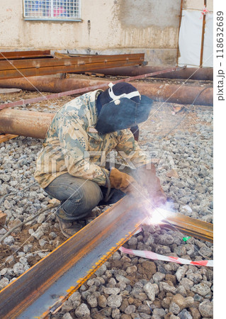 Welder in mask welding metal construction on open air. 118632689