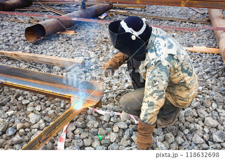 Welder in mask welding metal construction on open air. 118632698