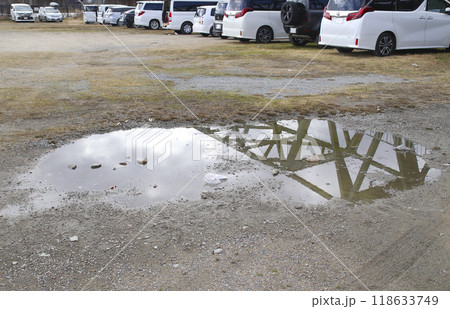 未舗装の駐車場と水たまり 118633749