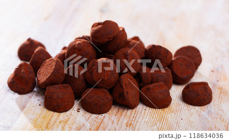 Dessert truffles sprinkled with cocoa on wooden table 118634036