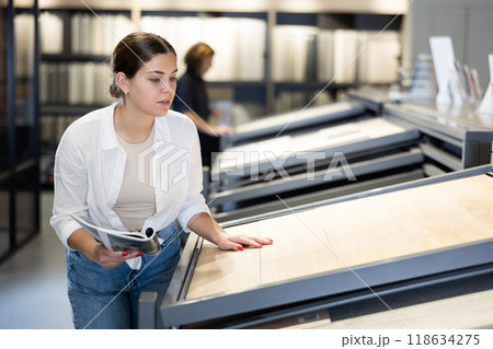 Confident female customer picking out wall tile materials for bathroom in hardware store 118634275