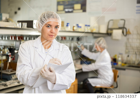 Young woman lab technician working, writing notes 118634337