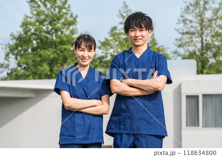 病院・施設の前にいるスクラブをきた医療従事者の男女スタッフ（作業療法士・看護師） 118634800