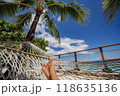 Beach travel holiday vacation woman feet selfie lying down relaxing on hammock outside sunbathing. Girl relaxing taking pov photo of her legs sun tanning in tropical summer destination 118635136