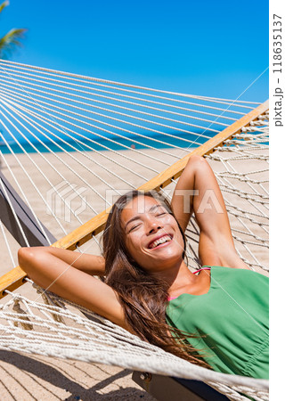 Beach vacation travel woman happy sleeping in hammock at holiday resort - Caribbean travel holidays Asian girl lying down relaxing outdoors sunbathing. Beach vacation travel woman happy sleeping in hammock at holiday resort - Caribbean travel holidays Asian girl lying down relaxing outdoors sunbathing. 118635137