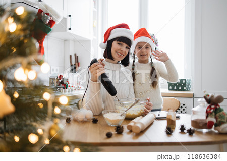 Mother and daughter baking together during Christmas holidays 118636384