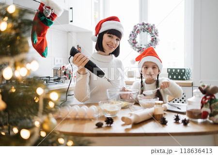 Mother and daughter baking cookies together for Christmas 118636413