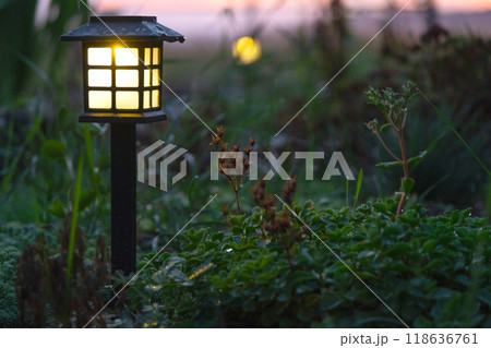 Solar-powered lanterns for flower beds in the yard of the house for decorative street lighting and landscaping 118636761