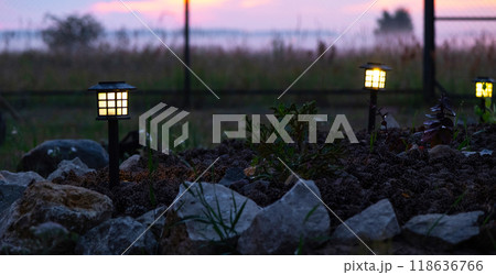 Solar-powered lanterns for flower beds in the yard of the house for decorative street lighting and landscaping 118636766