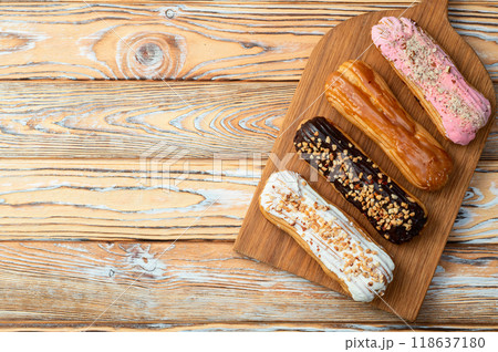 Assorted eclairs on a pastel top view Traditional French dessert 118637180