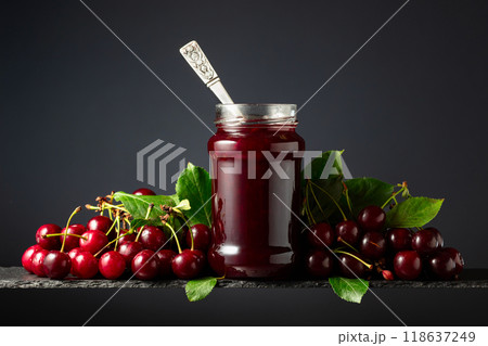 Cherry jam and fresh berries on a black background. Cherry jam and fresh berries on a black background. 118637249