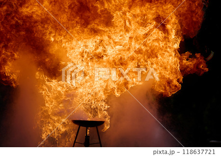 Fiery Explosion. A dramatic scene of an intense fiery explosion, capturing swirling flames against a dark background. 118637721