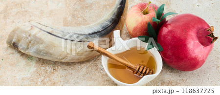Rosh Hashanah Symbols. Traditional items for Rosh Hashanah shofar, honey, apple, and pomegranate on a rustic background. 118637725