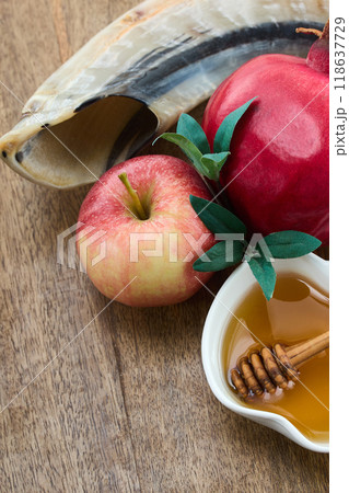 Rosh Hashanah Celebration Items. Pomegranate, apple, honey and shofar on wooden surface symbolizing Jewish New Year. Rosh Hashanah Celebration Items. Pomegranate, apple, honey and shofar on wooden surface symbolizing Jewish New Year. 118637729