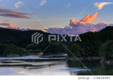 奈良市東部の布目ダム初秋の夕景　ダム湖の対岸で茜色に染まった雄大な積雲 118638465